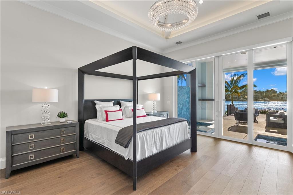 2649 Tarpon Road Naples, FL 34102 - Photo 18 of 50 a bedroom with a bed chandelier and a window