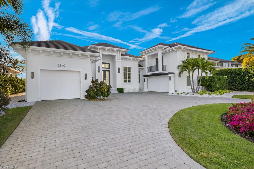 2649 Tarpon Road Naples, FL 34102 - Photo 2 of 50 a view of a white house with a big yard and potted plants