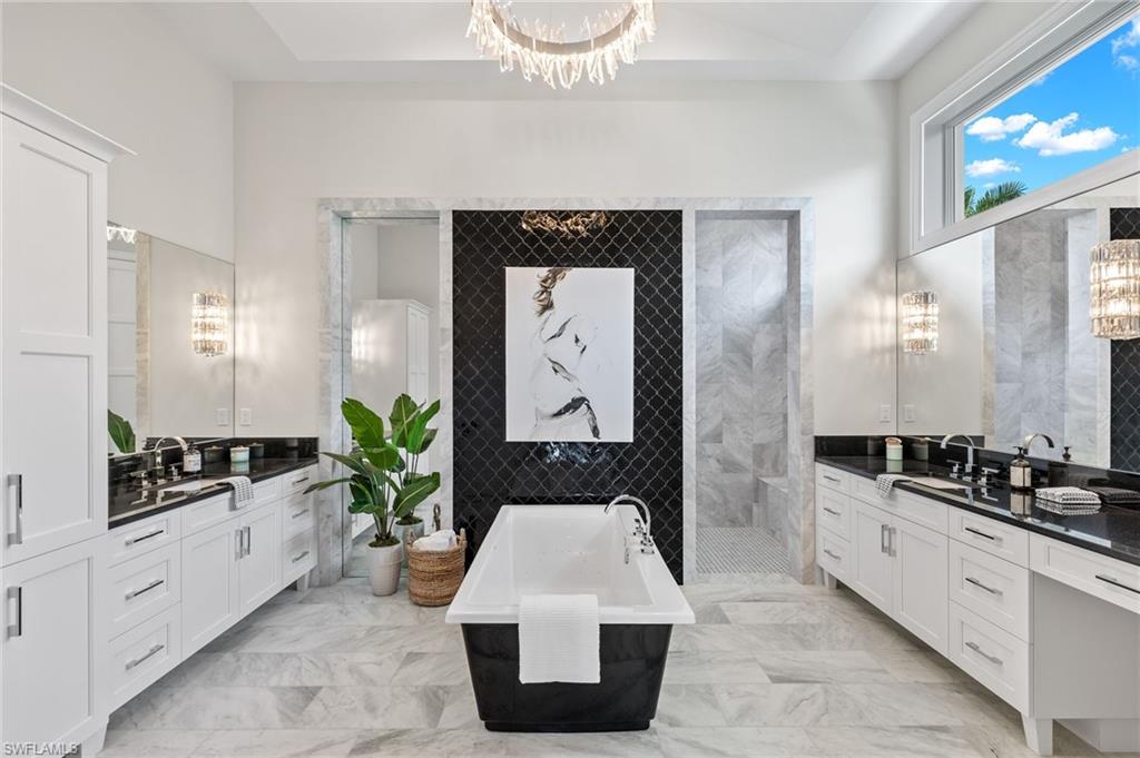 2649 Tarpon Road Naples, FL 34102 - Photo 21 of 50 a spacious bathroom with a bathtub a sink and a mirror