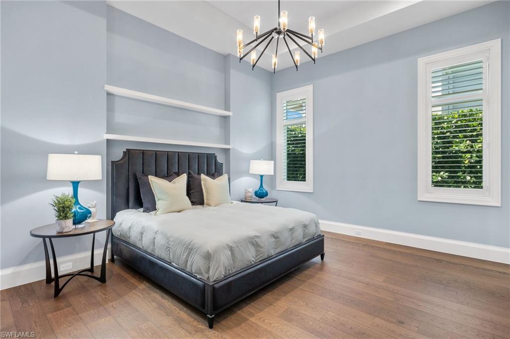 2649 Tarpon Road Naples, FL 34102 - Photo 26 of 50 a bedroom with a bed a chandelier and a window
