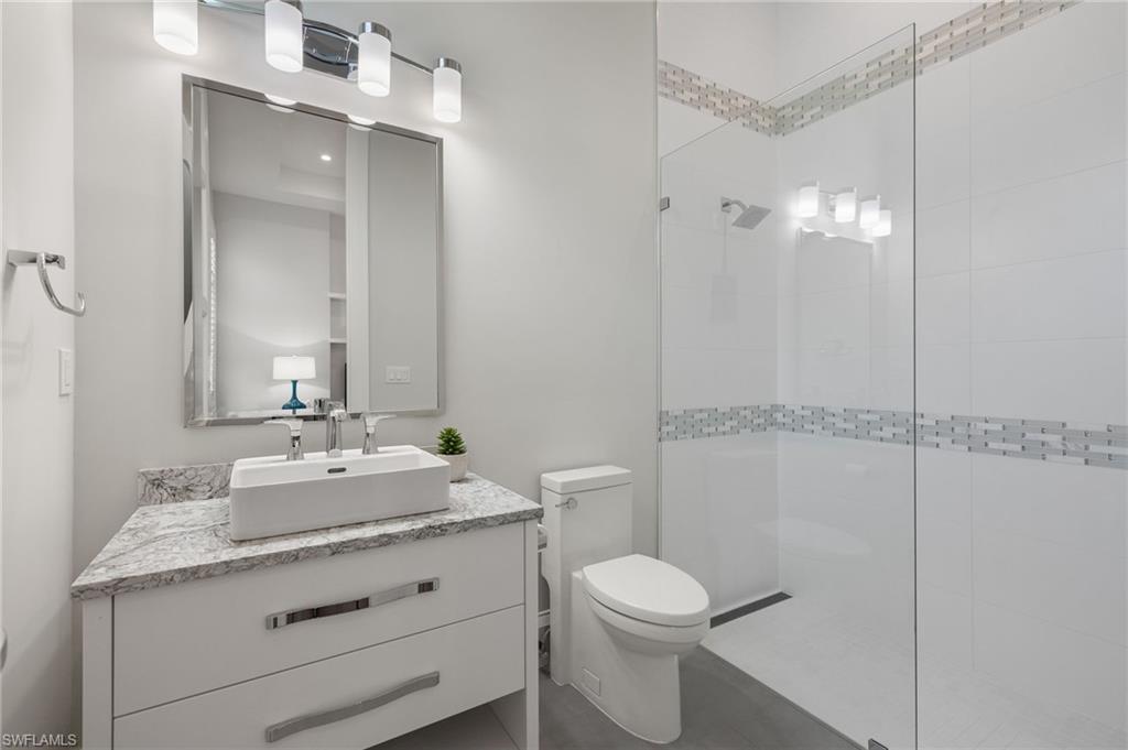 2649 Tarpon Road Naples, FL 34102 - Photo 27 of 50 a bathroom with a granite countertop sink toilet and shower