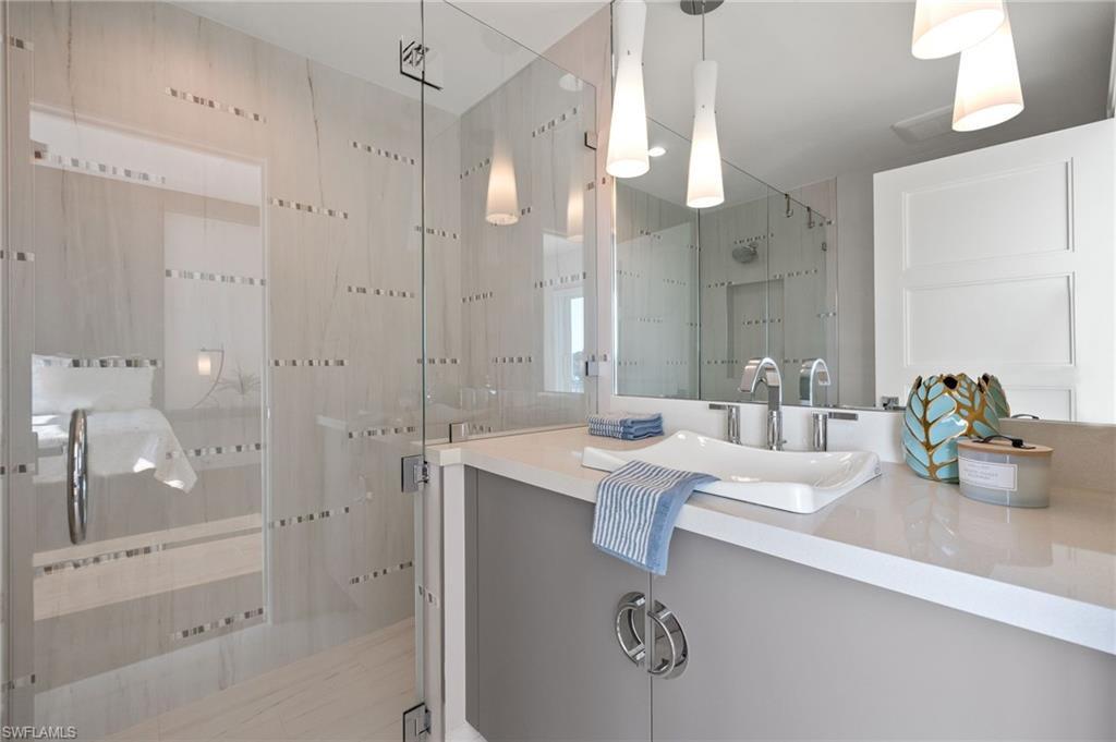 2649 Tarpon Road Naples, FL 34102 - Photo 30 of 50 a bathroom with a granite countertop sink mirror and shower