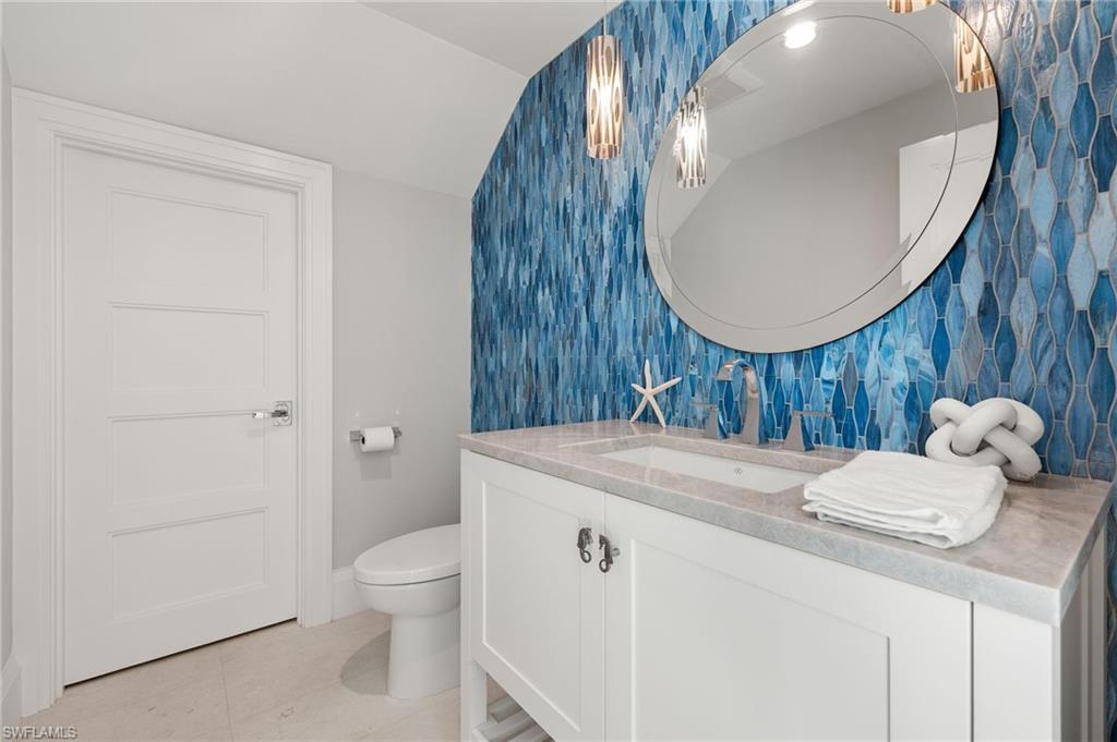 2649 Tarpon Road Naples, FL 34102 - Photo 34 of 50 a bathroom with a sink a toilet and a mirror