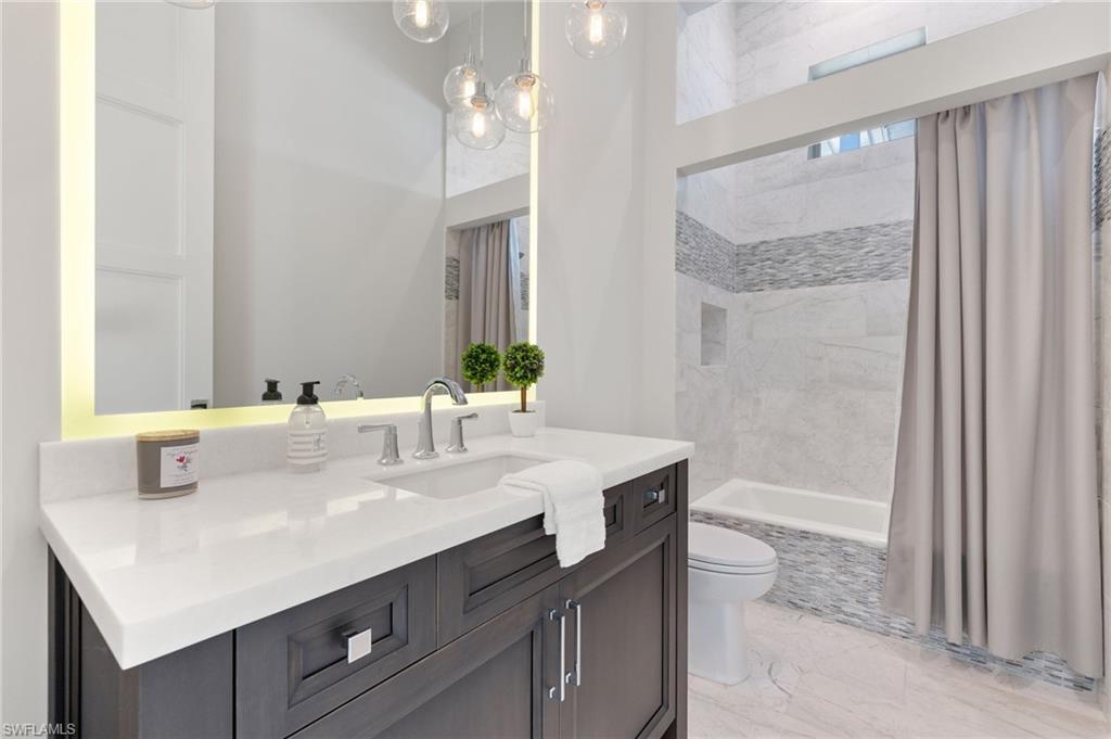 2649 Tarpon Road Naples, FL 34102 - Photo 36 of 50 a bathroom with a sink a mirror and a bathtub