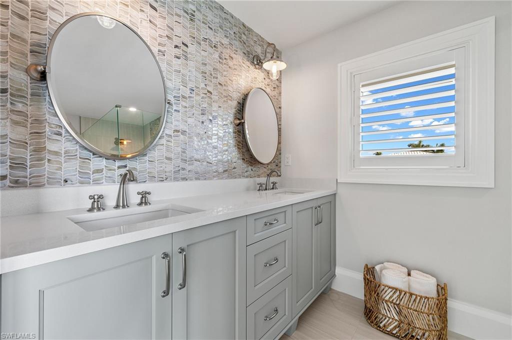 2649 Tarpon Road Naples, FL 34102 - Photo 38 of 50 a bathroom with a double vanity sink and a mirror