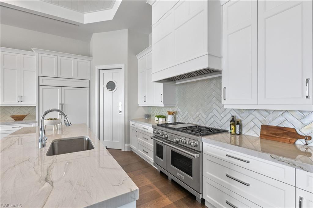 2649 Tarpon Road Naples, FL 34102 - Photo 10 of 50 a kitchen with stainless steel appliances granite countertop a sink stove and white cabinets