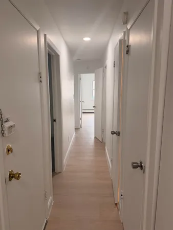 a view of a hallway with wooden cabinets