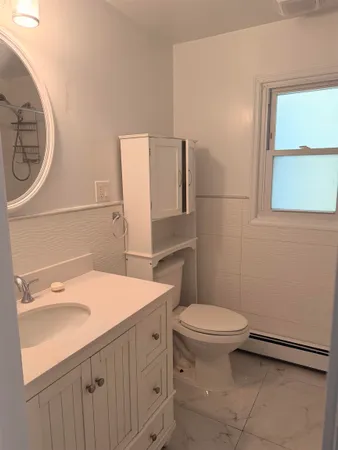 a bathroom with a sink a toilet and a mirror