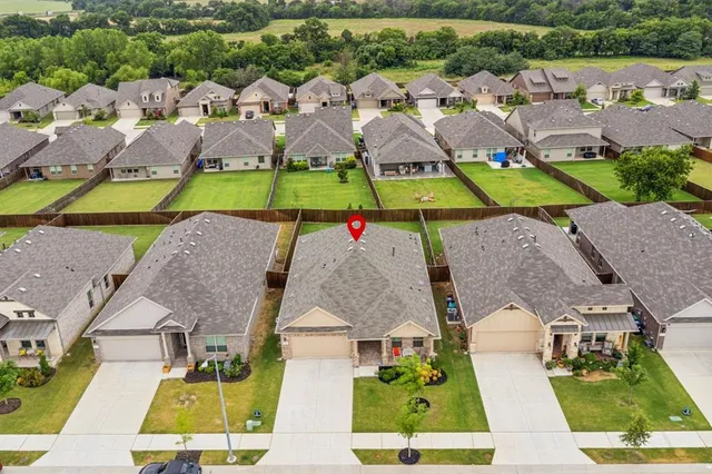an aerial view of residential houses with outdoor space and parking