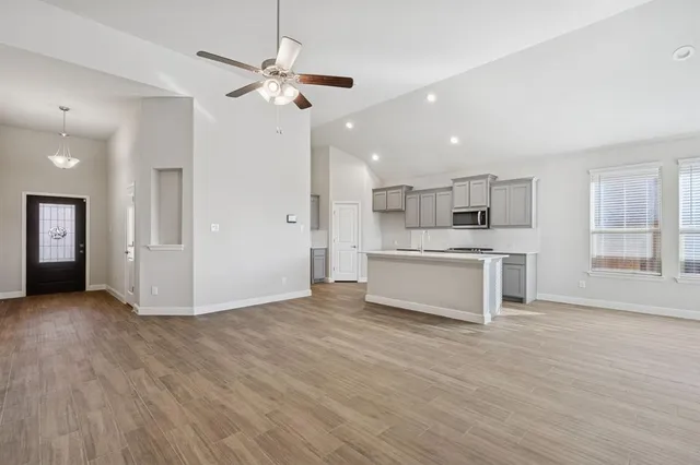 a view of kitchen with granite countertop cabinets and refrigerator