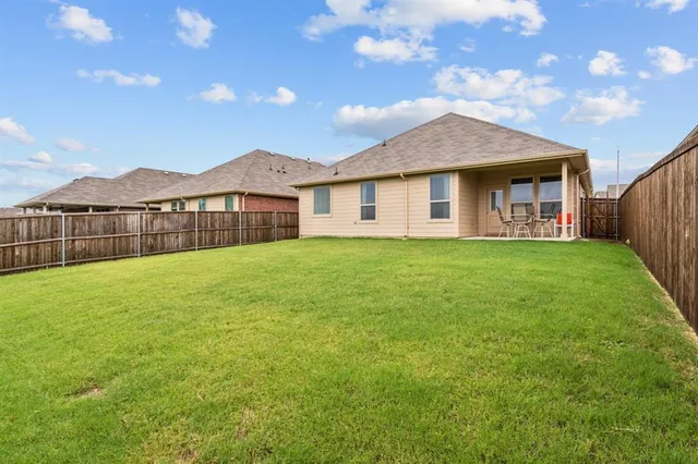 a view of a house with a yard and a large tree