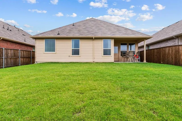 a view of a house with a yard and sitting area
