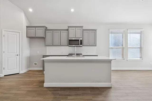 a kitchen with stainless steel appliances granite countertop a sink a stove and a refrigerator