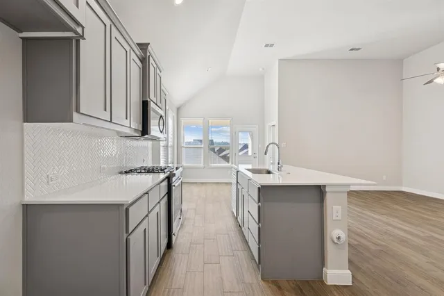 a kitchen with stainless steel appliances a sink stove and cabinets