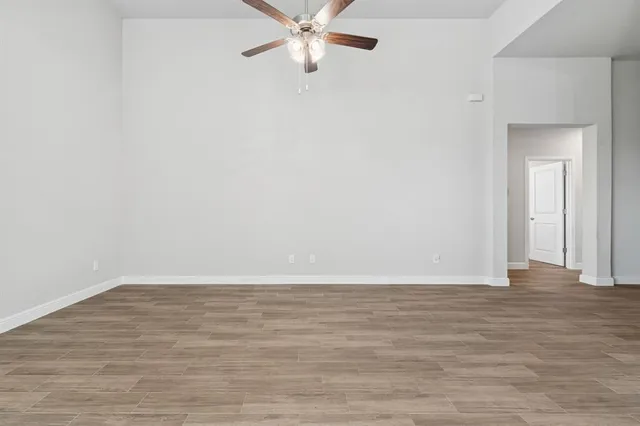a view of an empty room with wooden floor