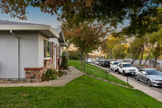 a view of a house with backyard and sitting area