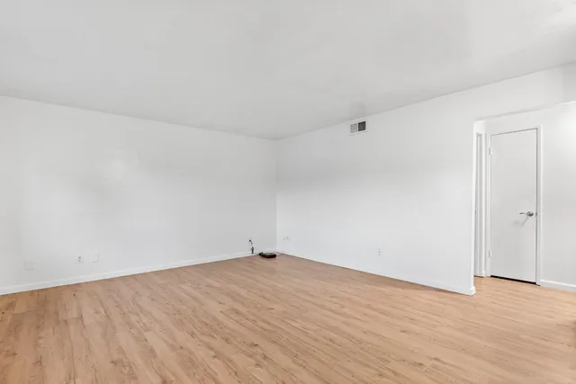 a view of an empty room and wooden floor