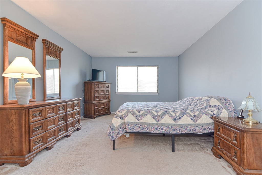 23 Tamarack Lane, Unit 23 Peabody, MA 01960 - Photo 21 of 42 a bedroom with a bed and a dresser