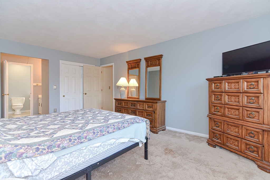 23 Tamarack Lane, Unit 23 Peabody, MA 01960 - Photo 22 of 42 a bedroom with a bed and a flat screen tv