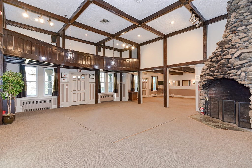 23 Tamarack Lane, Unit 23 Peabody, MA 01960 - Photo 37 of 42 a view of an empty room with a fireplace and a ceiling fan