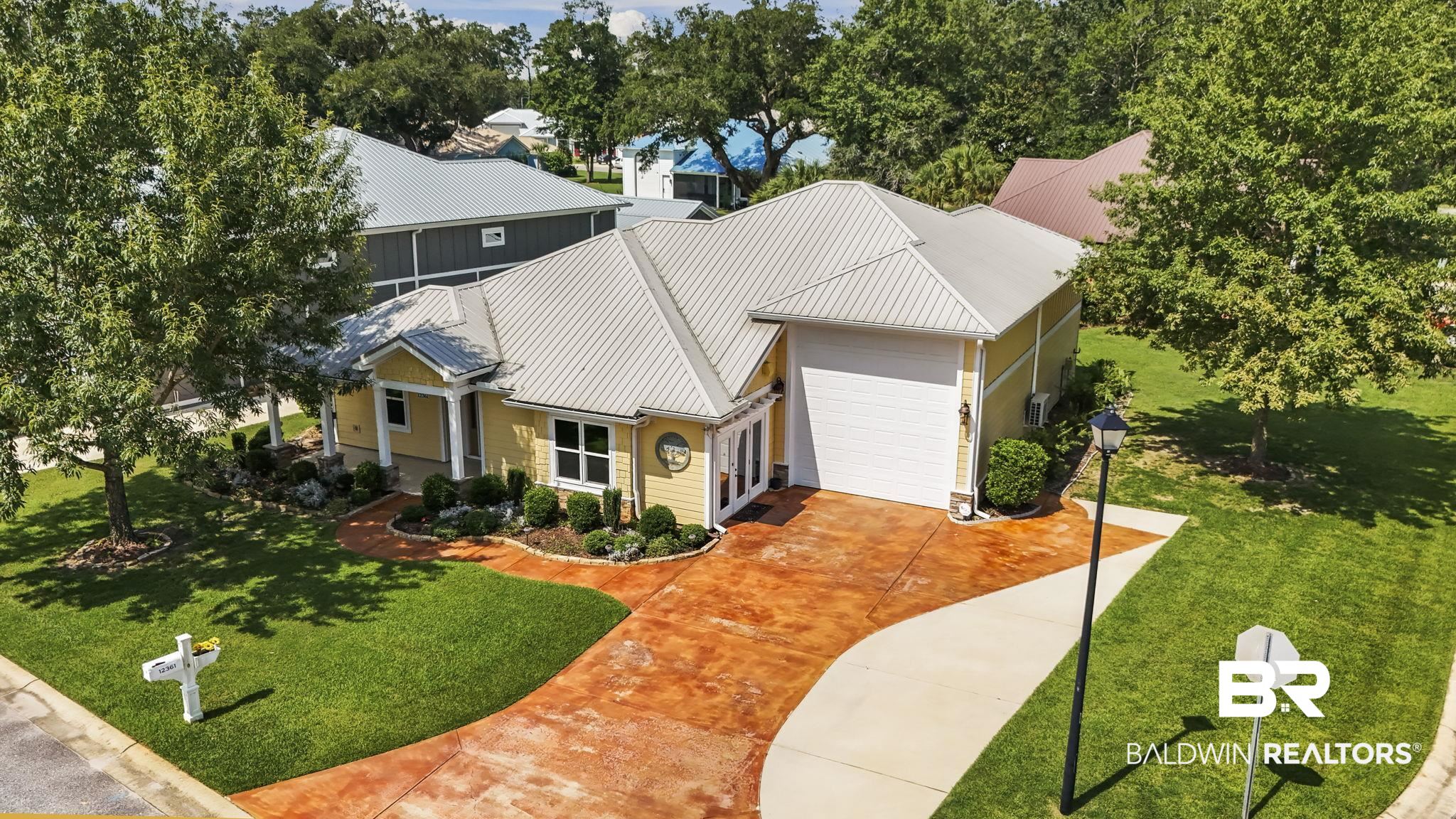 12361 Reunion Place Foley, AL 36535 - Photo 29 of 43 View of front facade with concrete driveway, a metal roof, a garage, and a front lawn