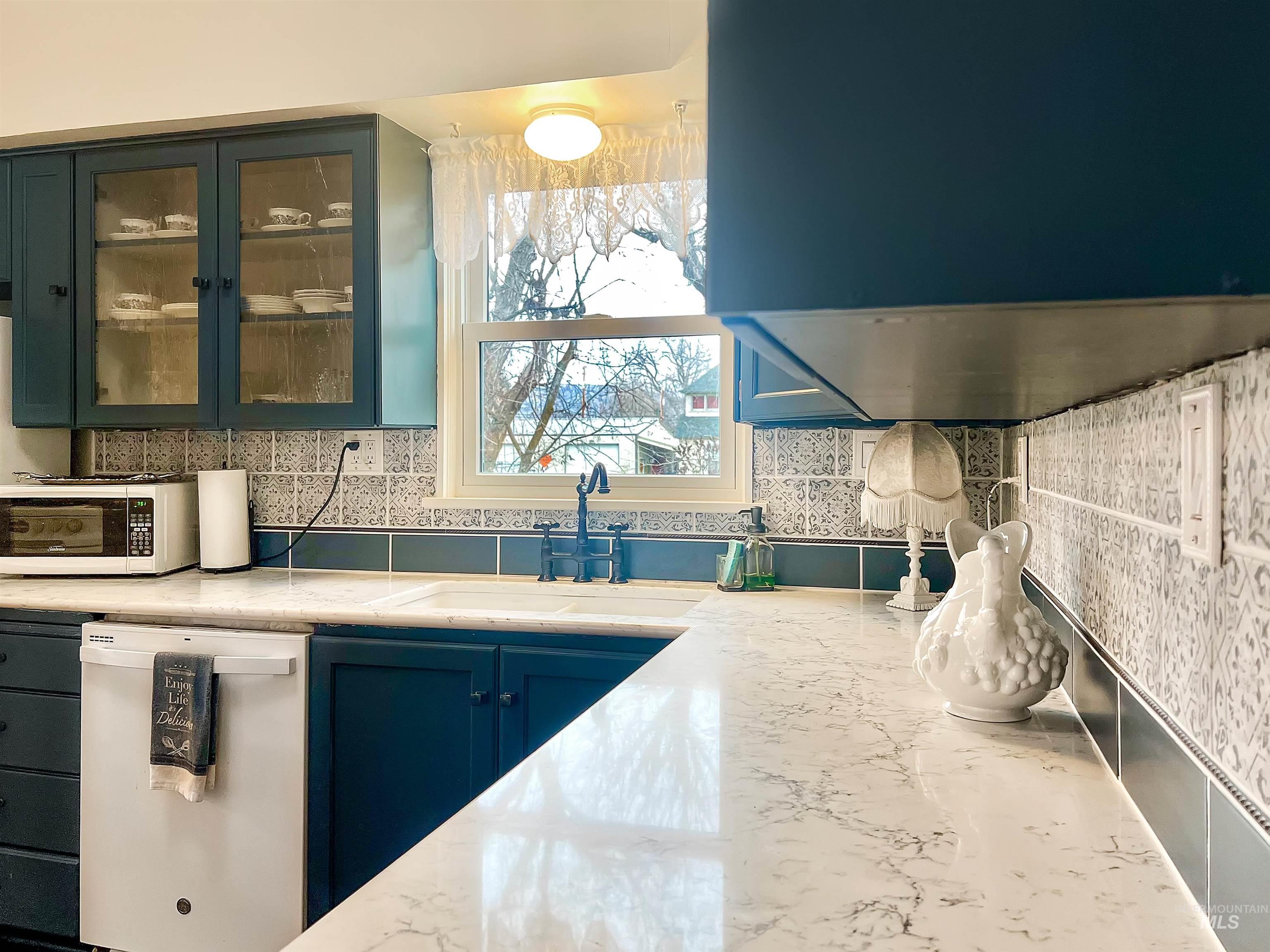 516 East Main Street Weiser, ID 83672 - Photo 21 of 50 Kitchen featuring white appliances, ventilation hood, decorative backsplash, blue cabinetry, and light stone countertops