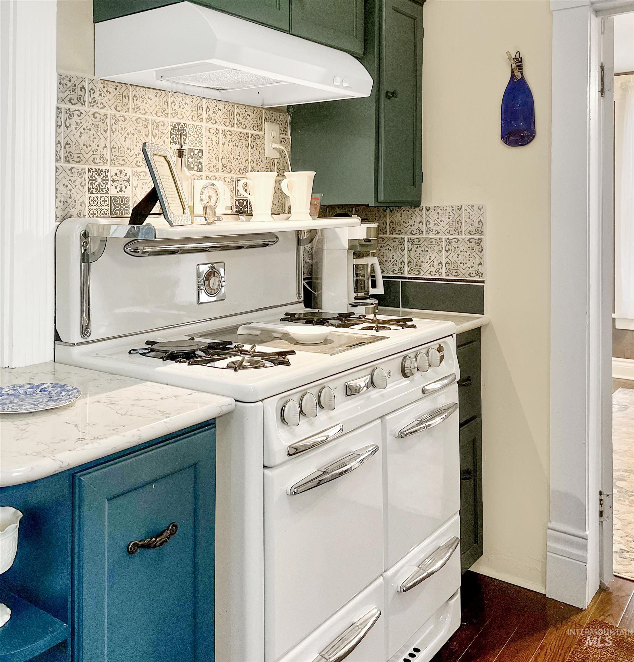 516 East Main Street Weiser, ID 83672 - Photo 22 of 50 Kitchen with double oven range, decorative backsplash, green cabinets, and dark wood-style flooring