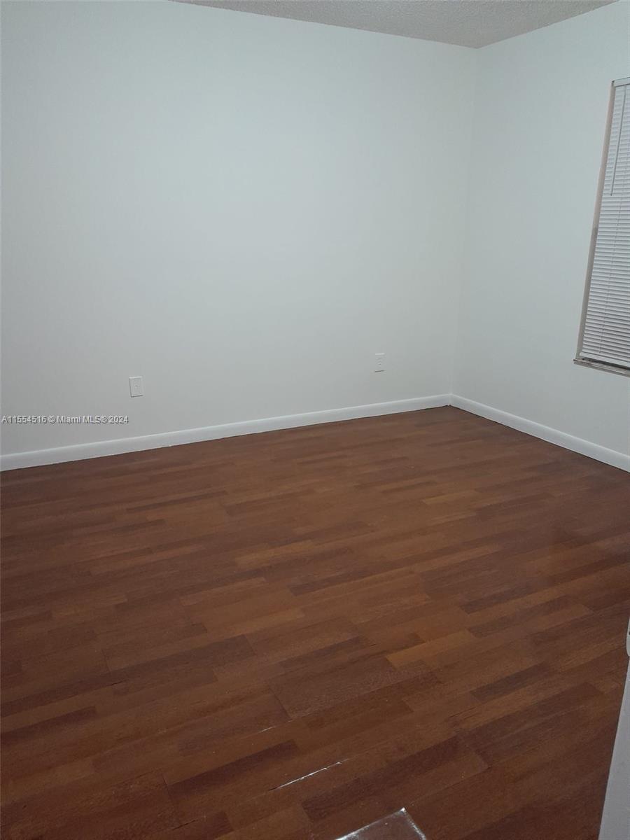 4241 West McNab Road, Unit 27 Pompano Beach, FL 33069 - Photo 11 of 29 an empty room with wooden floor