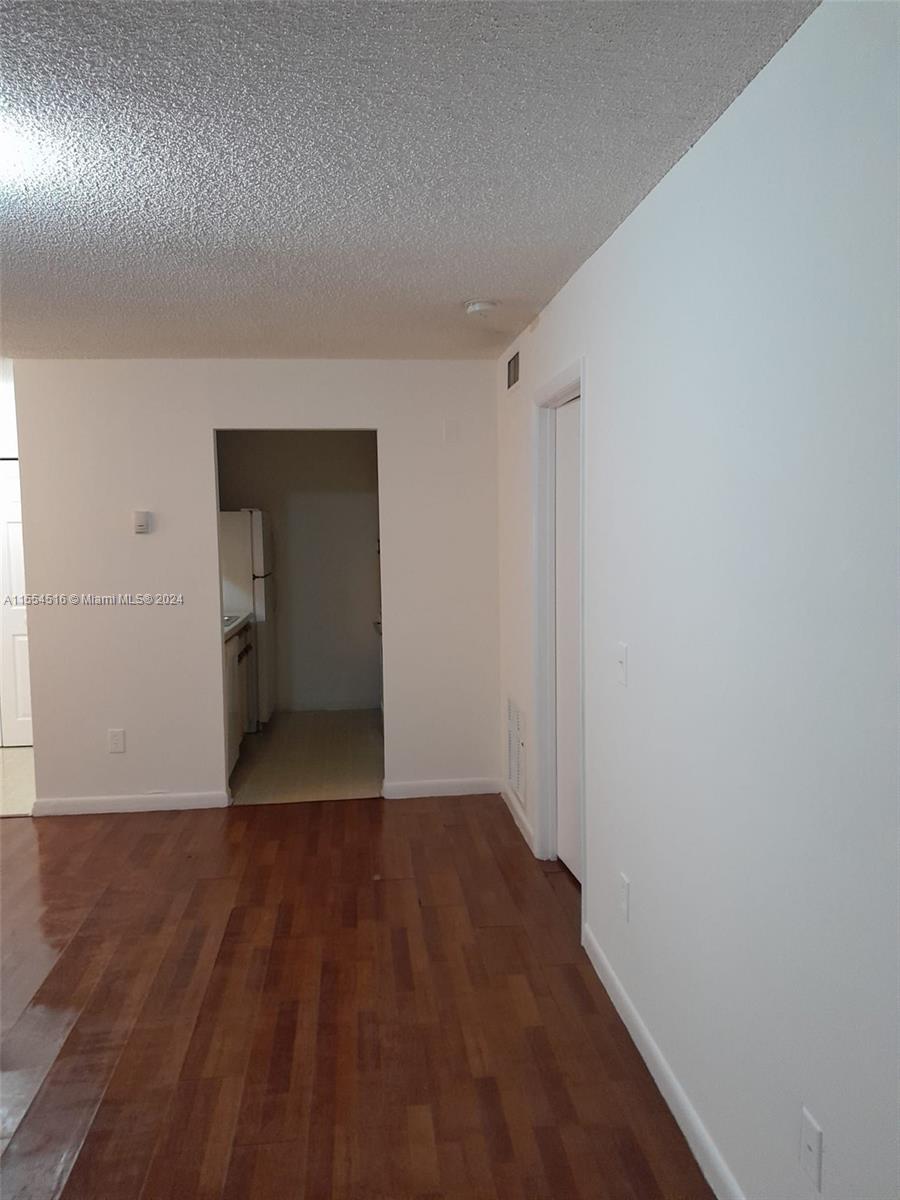 4241 West McNab Road, Unit 27 Pompano Beach, FL 33069 - Photo 13 of 29 a view of an empty room with wooden floor