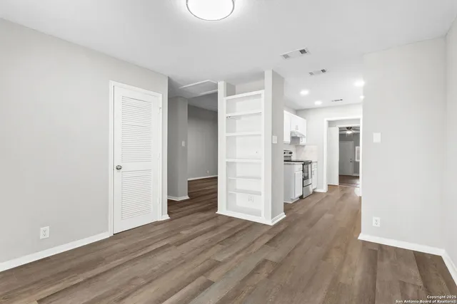 a view of a kitchen with a refrigerator and wooden floor