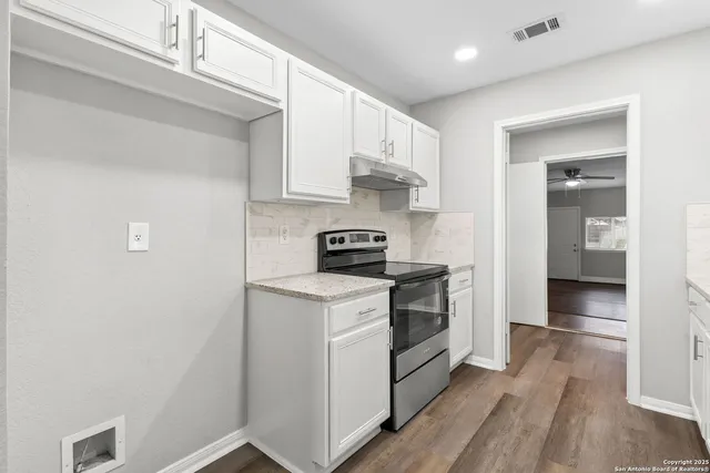 a kitchen with a stove cabinets and a refrigerator