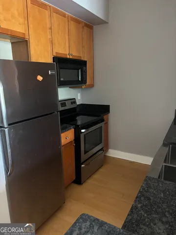 a kitchen with a refrigerator and a stove