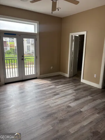 an empty room with wooden floor and windows