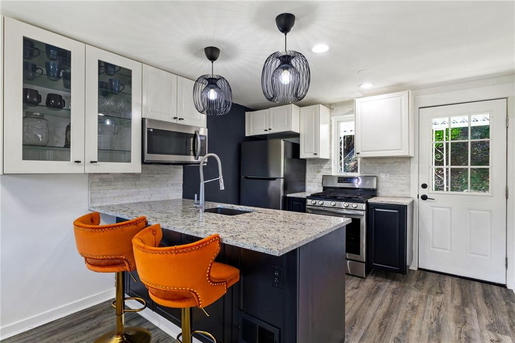 8144 Lincoln Road Verona, PA 15147 - Photo 13 of 33 a kitchen with stainless steel appliances granite countertop a kitchen island a stove a table and chairs in it