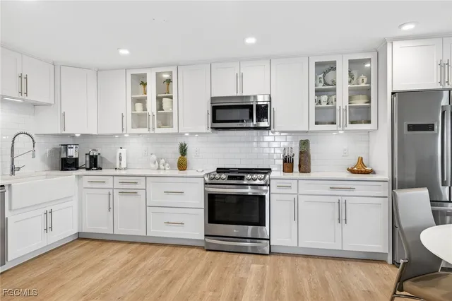 a kitchen with stainless steel appliances granite countertop a stove a sink and a microwave