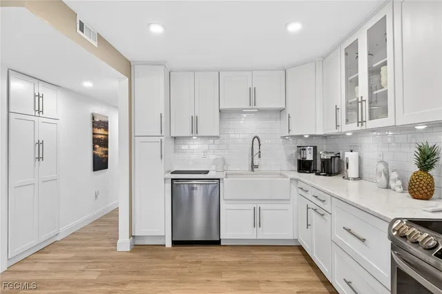 a kitchen with white cabinets and appliances