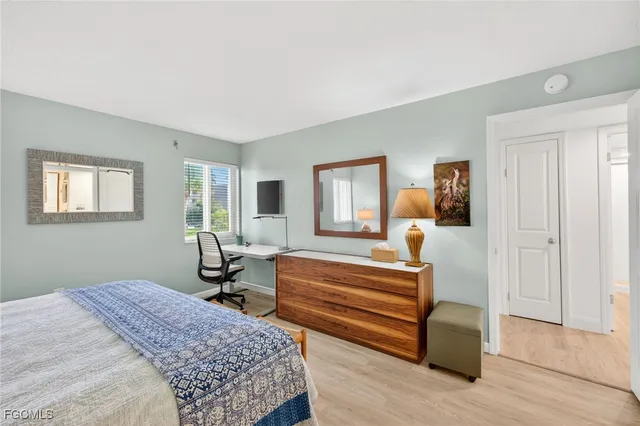 a bedroom with a bed a table and painting on the wall