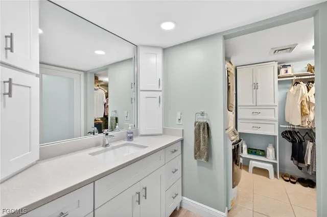 a bathroom with a double vanity sink a mirror a washer and dryer