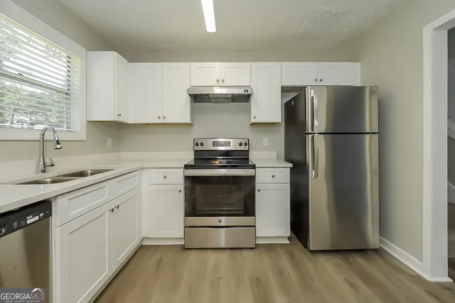 a kitchen with a sink a refrigerator and a stove