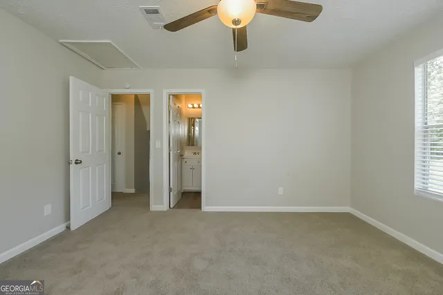en empty room with windows and chandelier fan