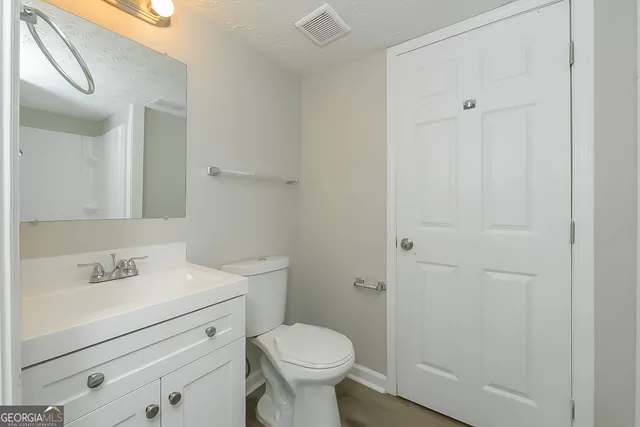 a bathroom with a sink toilet and a mirror