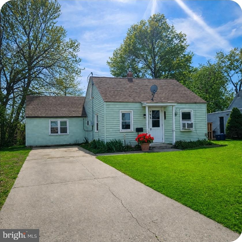 a front view of a house with a yard and trees