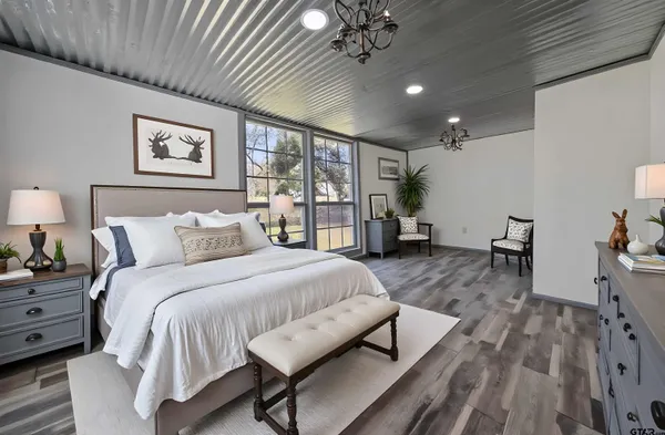 a spacious bedroom with a bed window and a table