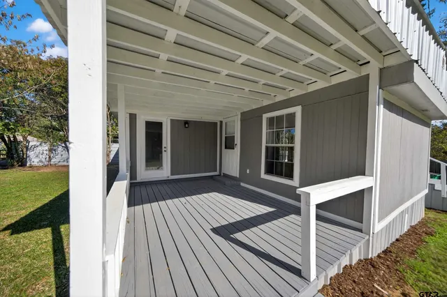 a view of backyard with wooden floor and fence