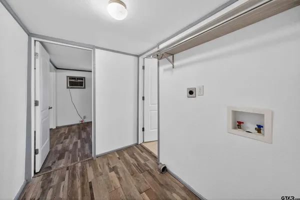 a view of a hallway with wooden floor and entryway