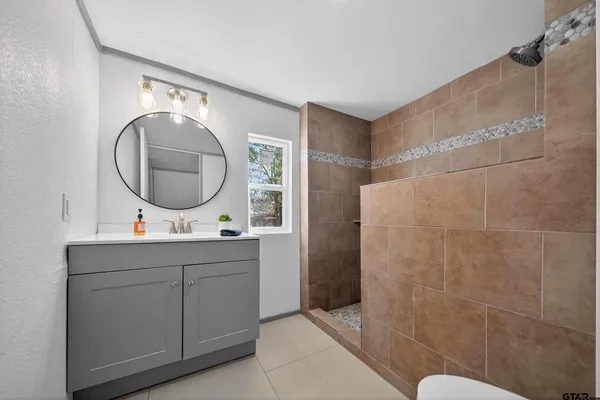 a bathroom with a sink mirror and toilet
