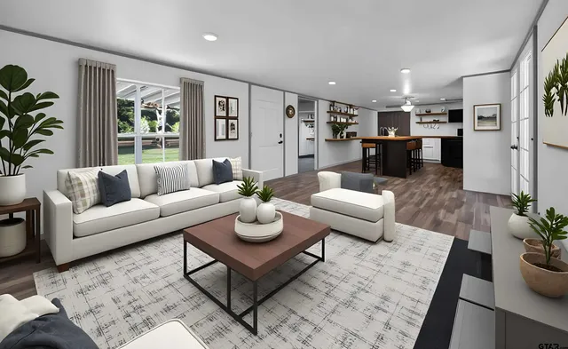 a living room with furniture potted plant kitchen view and large windows