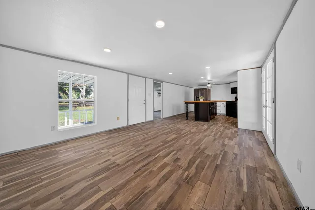 a view of empty room with wooden floor and window