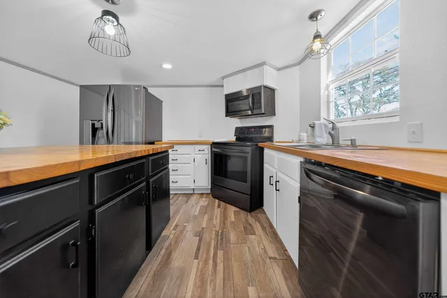 a kitchen with stainless steel appliances granite countertop a sink dishwasher a stove and a refrigerator with wooden floor