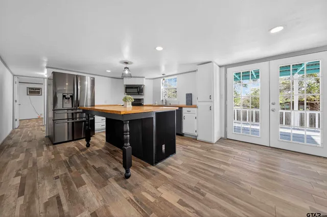 a kitchen with stainless steel appliances kitchen island granite countertop a refrigerator and a stove top oven